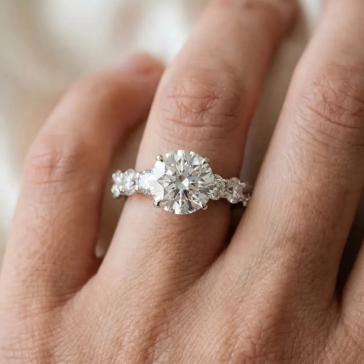 Round Cut Diamond Prong Setting with Side Stones on a Pave Band White gold