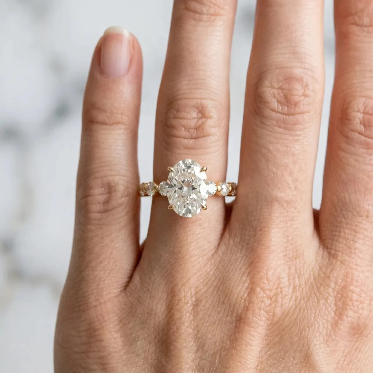 Oval Cut Solitaire Diamond Ring with Pave Band and Four-Prong Setting Yellow gold
