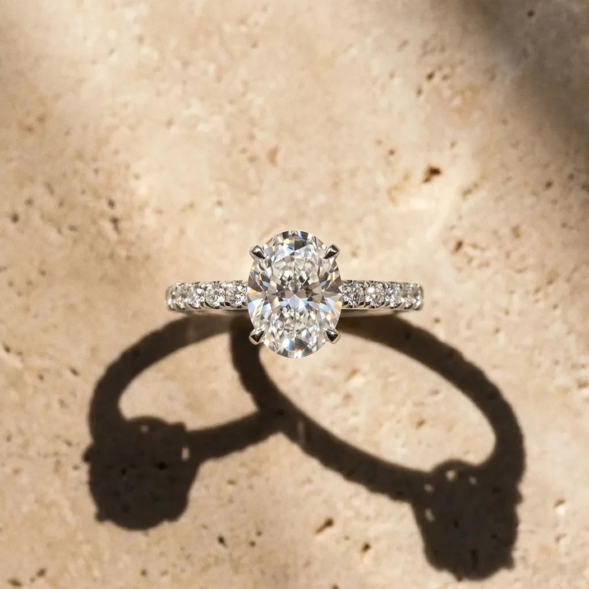 Oval Cut Diamond Solitaire Ring with Round Pavé Band and Four-Prong Setting Platinum