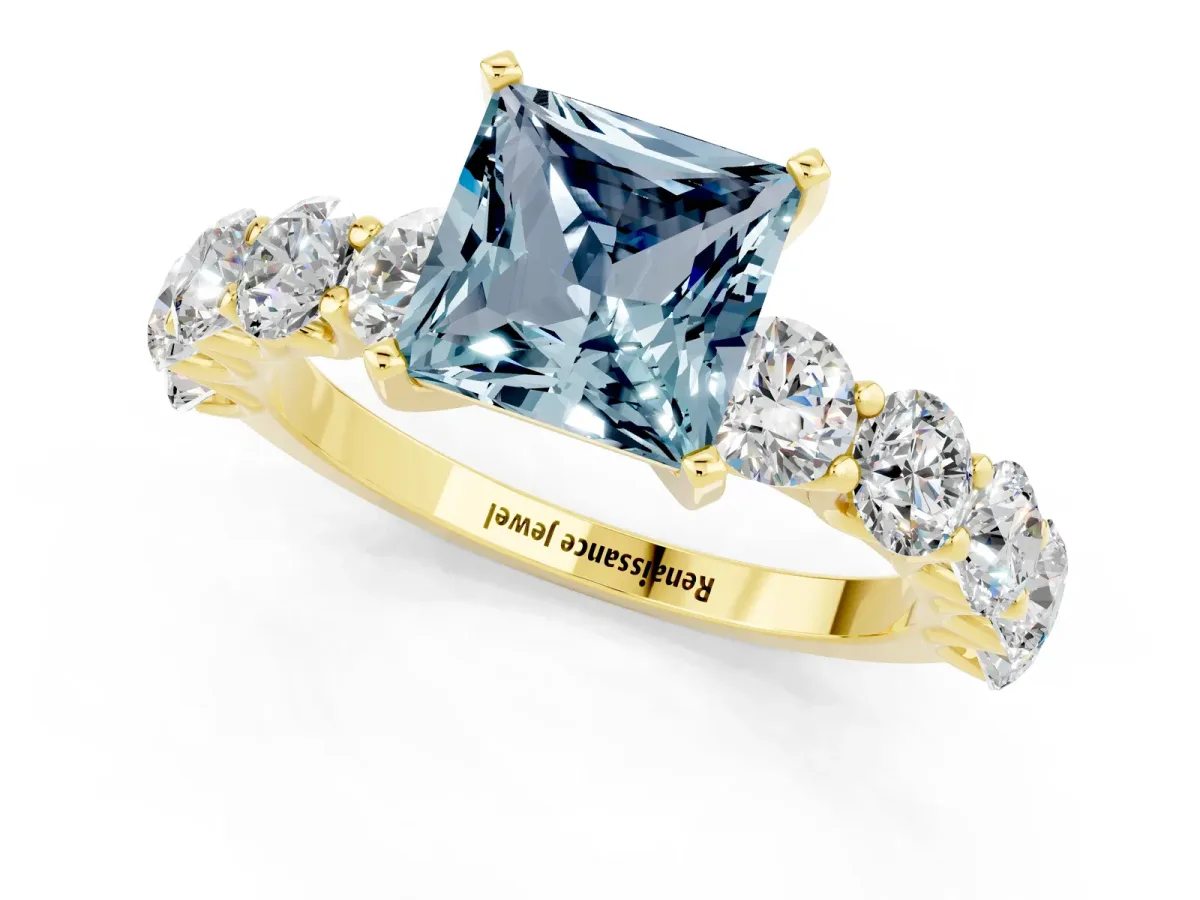Princess Cut Aquamarine Prong Setting with Side Stones on a Pave Band Yellow gold