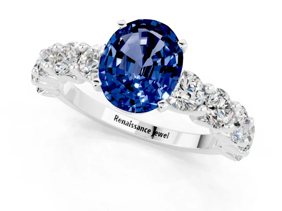 Oval Cut Blue Sapphire Prong Setting with Side Stones on a Pave Band Silver