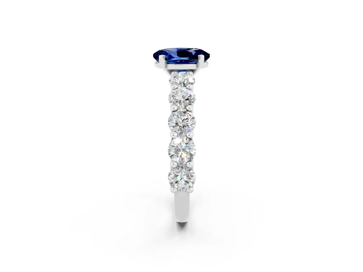 Oval Cut Blue Sapphire Prong Setting with Side Stones on a Pave Band Silver