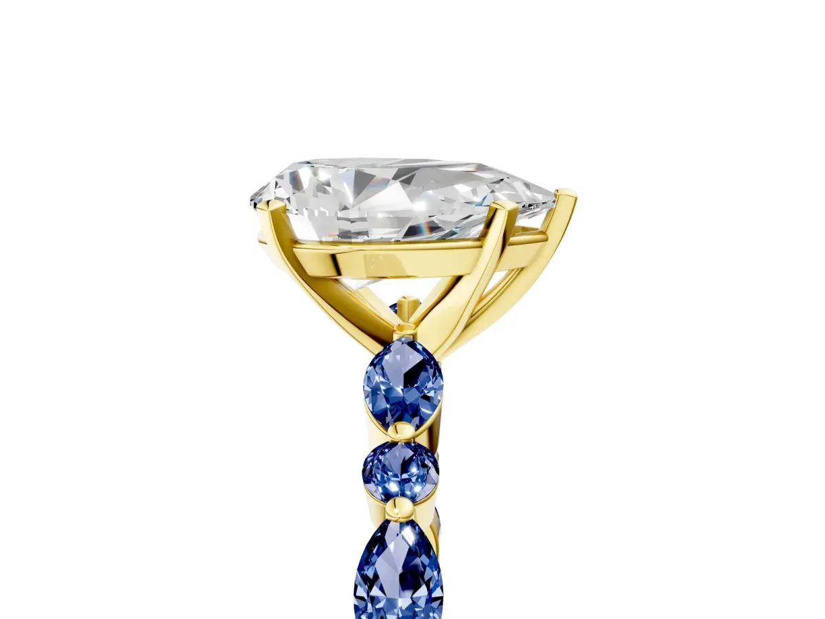 Pear Cut Diamond Ring with Marquise and Round Blue Sapphire Side Stones and Four-Prong Setting Yellow gold