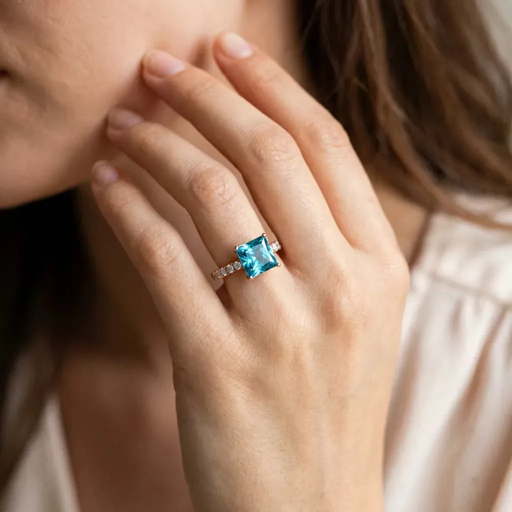 Princess Cut Blue Topaz Solitaire Ring with Round Pavé Band and Four-Prong Setting Rose gold