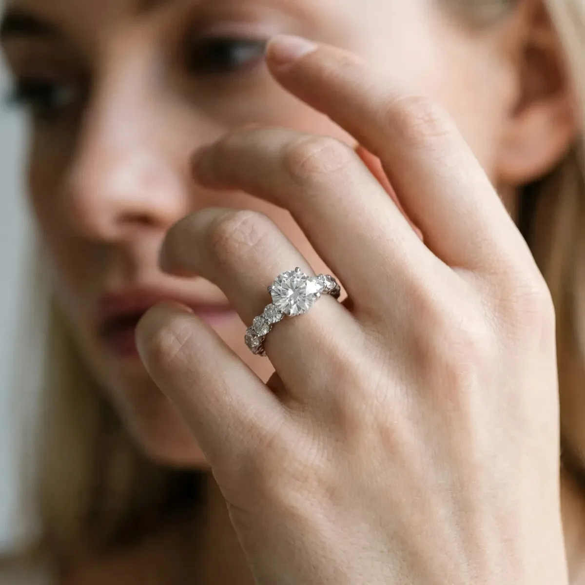 Round Cut Diamond Prong Setting with Side Stones on a Pave Band White gold