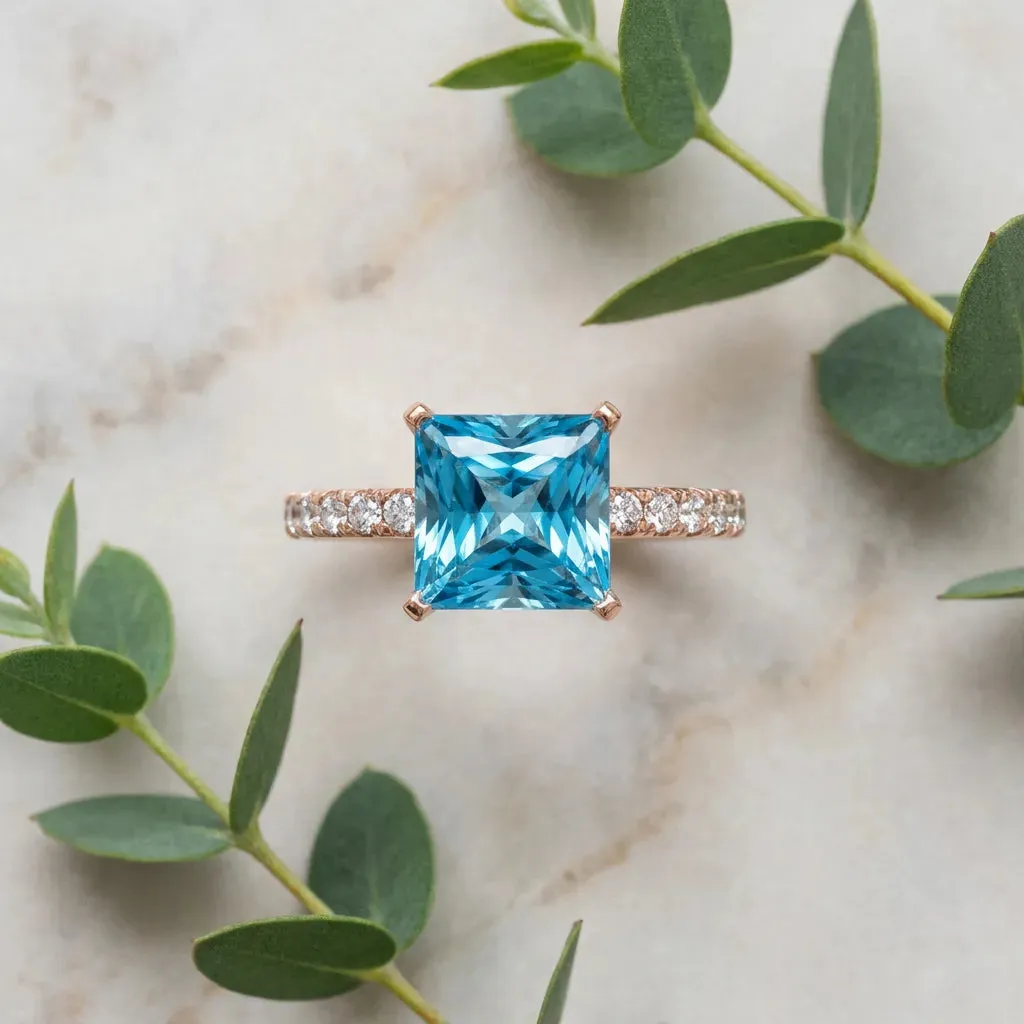 Princess Cut Blue Topaz Solitaire Ring with Round Pavé Band and Four-Prong Setting Rose gold
