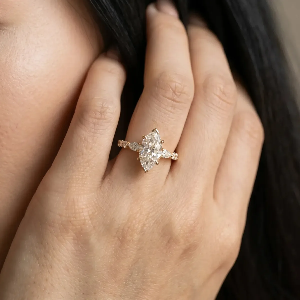 Marquise Cut Diamond Ring with Marquise and Round Side Stones and Four-Prong Setting Yellow gold
