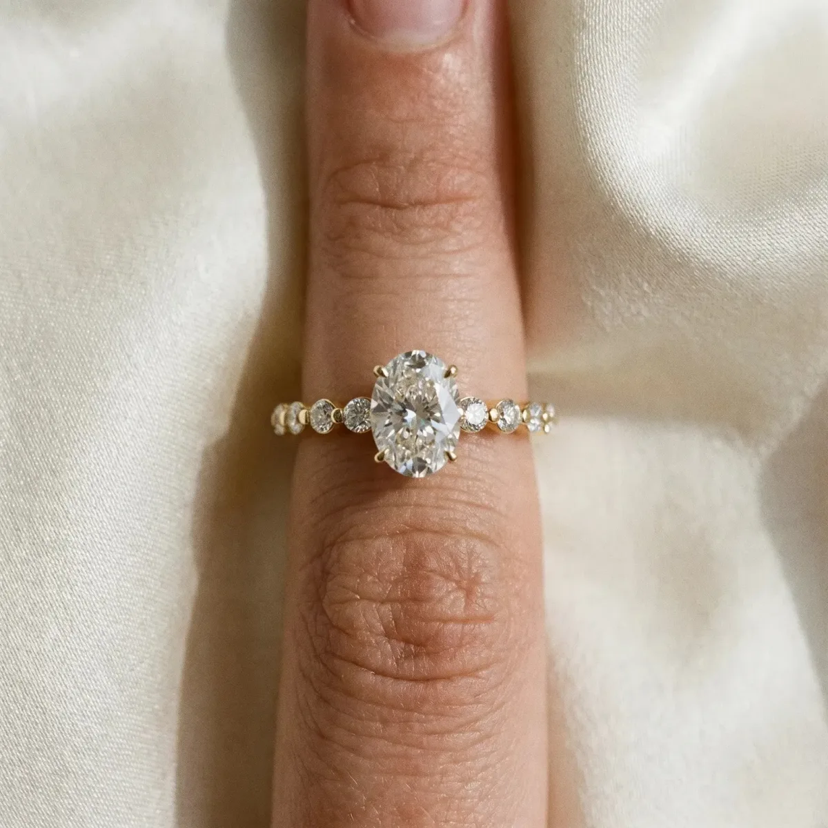 Oval Cut Solitaire Diamond Ring with Pave Band and Four-Prong Setting Yellow gold