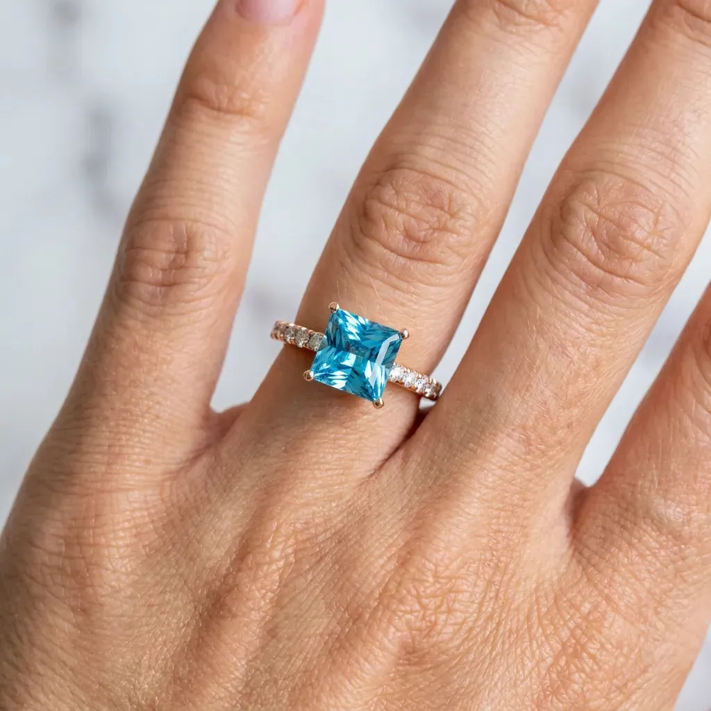 Princess Cut Blue Topaz Solitaire Ring with Round Pavé Band and Four-Prong Setting Rose gold